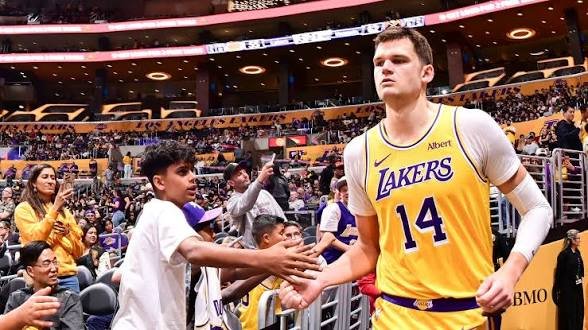 Walker Kessler in a gold Lakers number 14 jersey on the court.